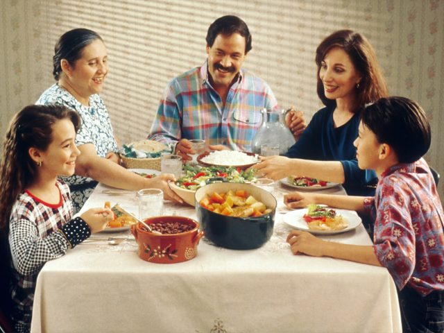 Famille avec des enfants qui partage un repas a table
