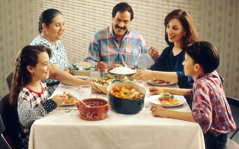 Famille avec des enfants qui partage un repas a table