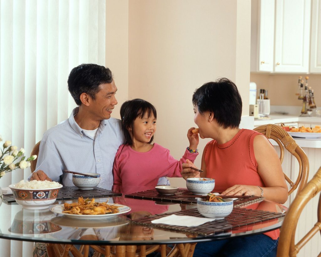 Famille de trois personnes attablee autour d un repas
