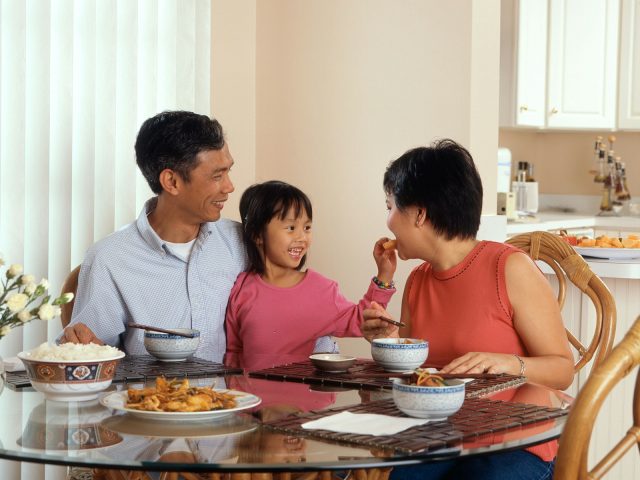 Famille de trois personnes attablee autour d un repas