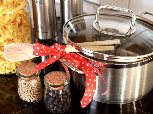 Marmite en inox avec ustensiles en bois et epices, preparation de repas