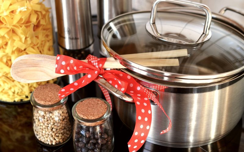 Marmite en inox avec ustensiles en bois et epices, preparation de repas