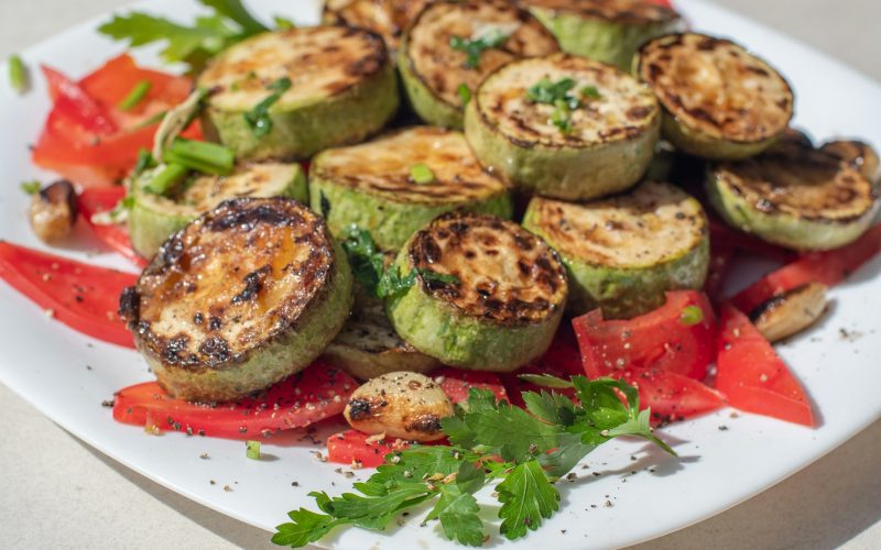 Courgettes farcies garnies de tomates, servies dans une assiette