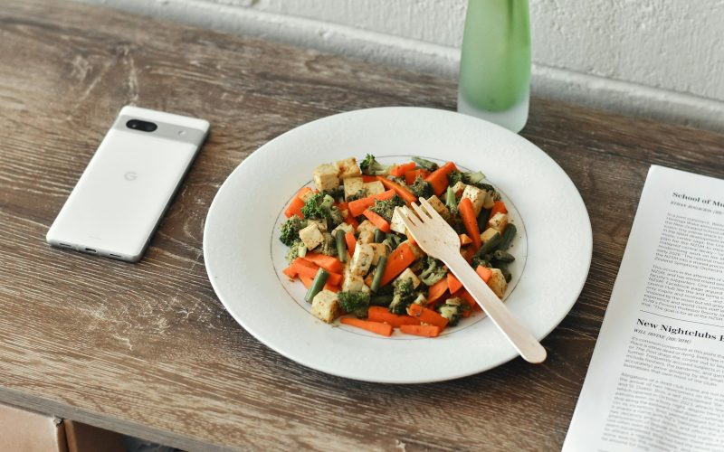 Assiette de salade composee avec telephone et magazine a cote