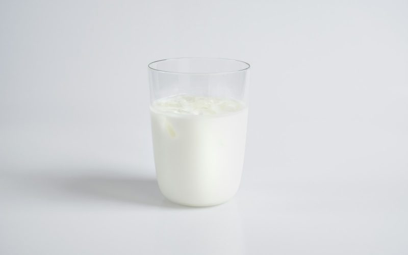 Verre de lait plein sur fond clair