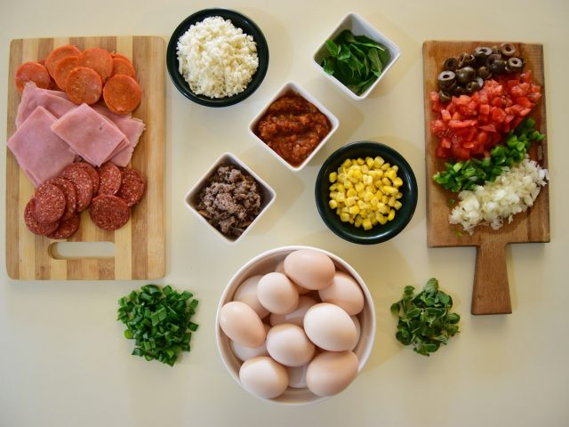 Plateau vu de dessus avec oeufs, jambon, fromage et legumes, sources de proteines