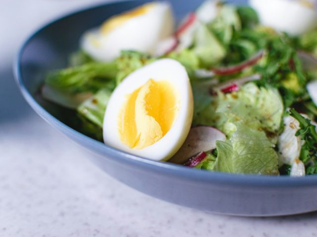 Bol bleu avec oeuf dur, legumes verts et herbes, assiette equilibree