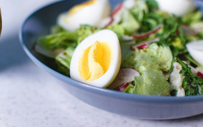Bol bleu avec oeuf dur, legumes verts et herbes, assiette equilibree